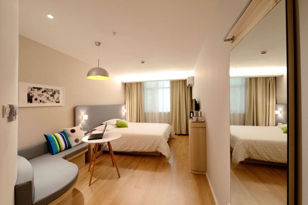 Bright bedroom with white bedding, warm wood, and natural light